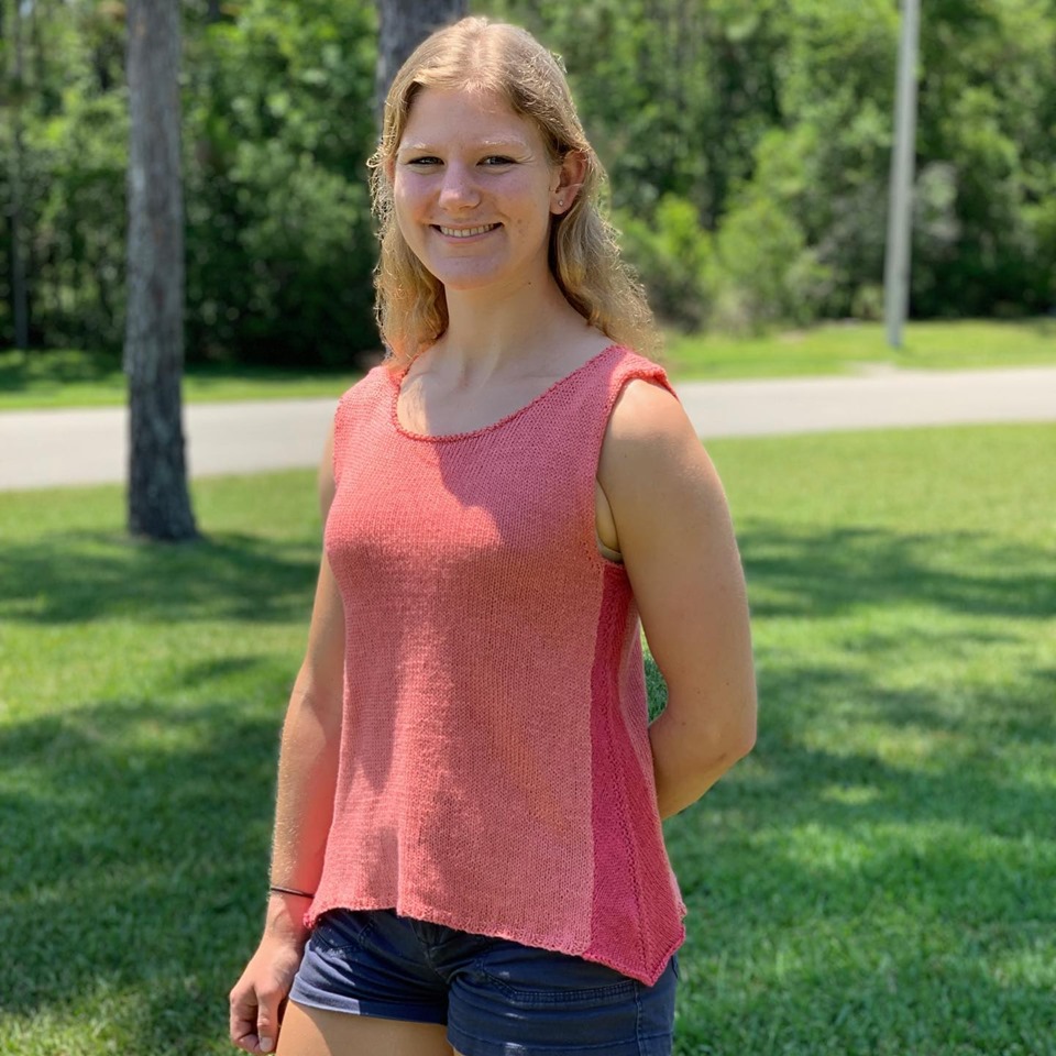 Young woman wearing handknit tank using a silk and linen blend sport weight yarn.  Image has link to She Sells Yarn website